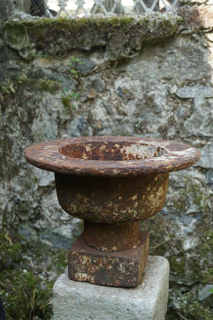 PAIR 19TH-CENTURY CAST IRON JARDINIERES: each raised on a square chamfered moulded stone pillar. 115 cm. high; 37 cm. in diameter; Approximate Time: 10:10 Lot No: 413 Category: Garden & Decorative Objects