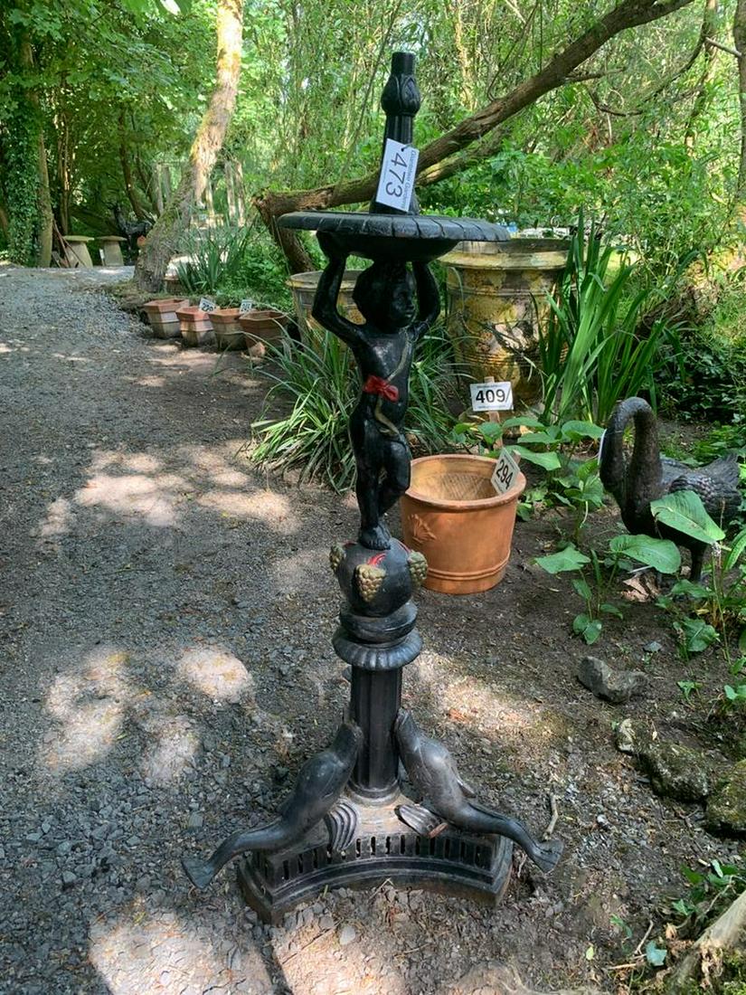 LARGE CAST IRON GARDEN CENTREPIECE: the turned disc-shaped top, raised on a cherub stem, mounted on a dolphin scroll base. 167 cm. high; Approximate Time: 11:04 Lot No: 473 Category: Garden & Decorative Objects