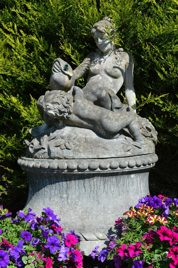 LARGE ITALIANATE STONE FOUNTAIN: Venus and a cherub, holding a bunch of grapes and a cymbal, seated on a circular mound. Approximate Time: 12:01 Lot No: 536 Category: Garden & Decorative Objects