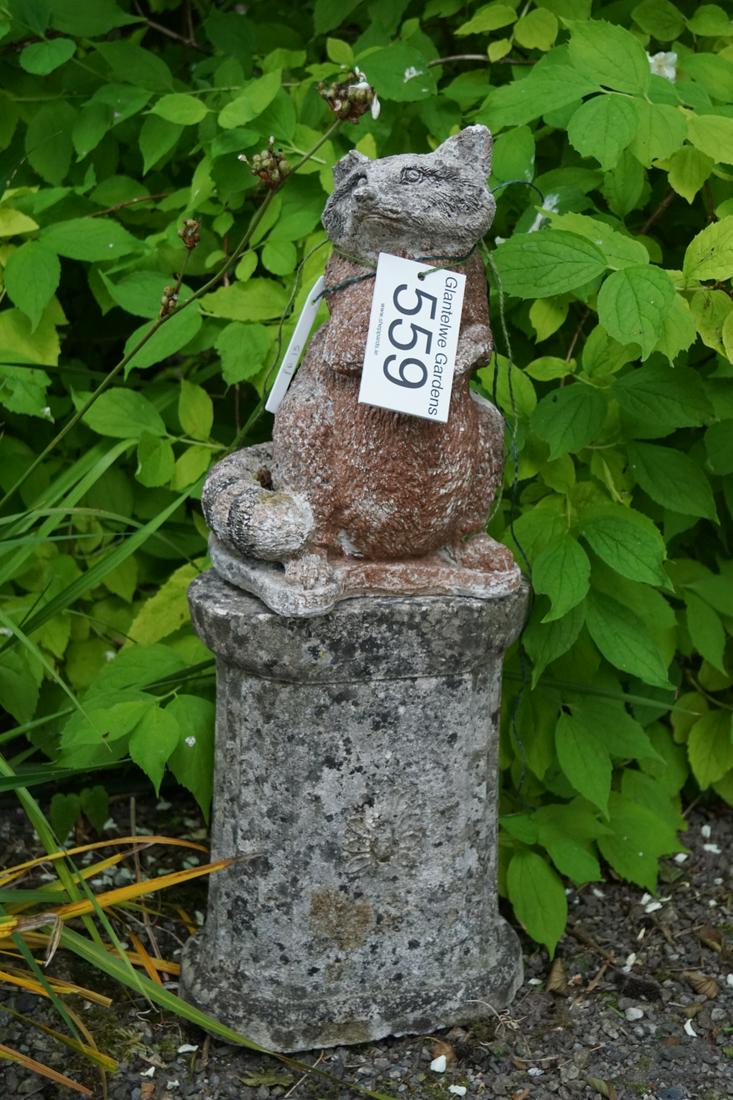 WEATHERED COMPOSITE STONE GARDEN ORNAMENT: of a raccoon, raised on a fluted plinth. 68 cm. high; Approximate Time: 12:22 Lot No: 559 Category: Garden & Decorative Objects