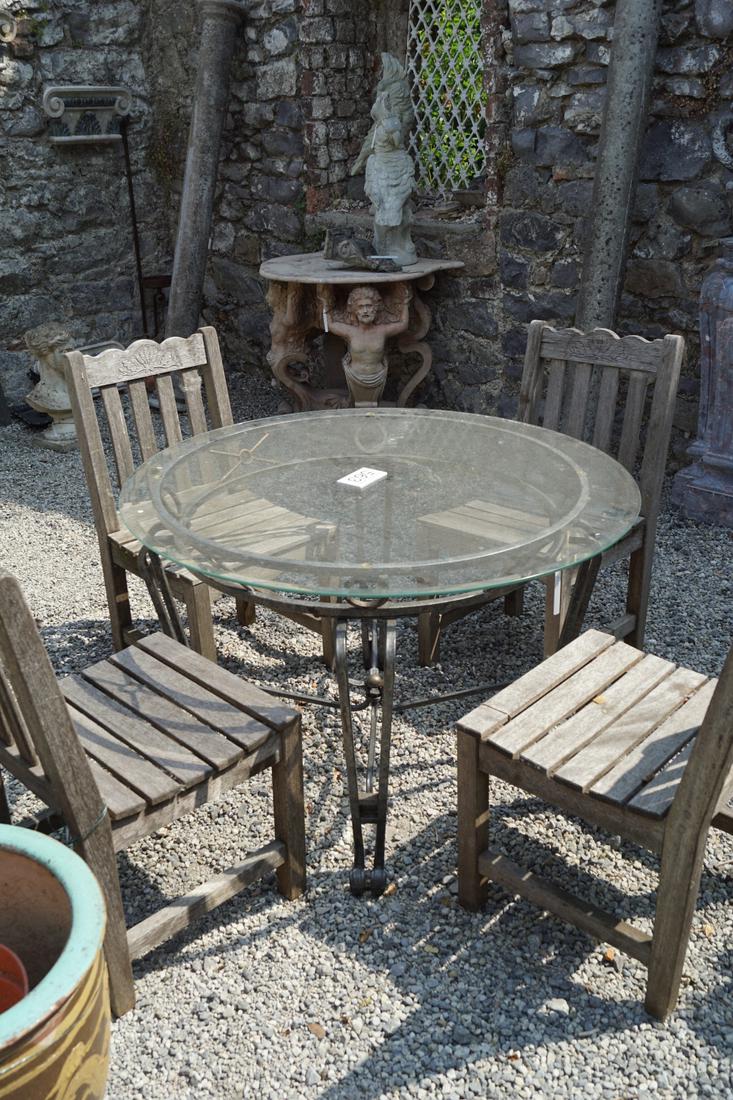 DESIGNER WROUGHT IRON GARDEN TABLE: the circular plate glass top raised on scroll legs joined by stretcher rails. 75 cm. high; 106 cm. in diameter; Approximate Time: 12:25 Lot No: 563 Category: Garden & Decorative Objects