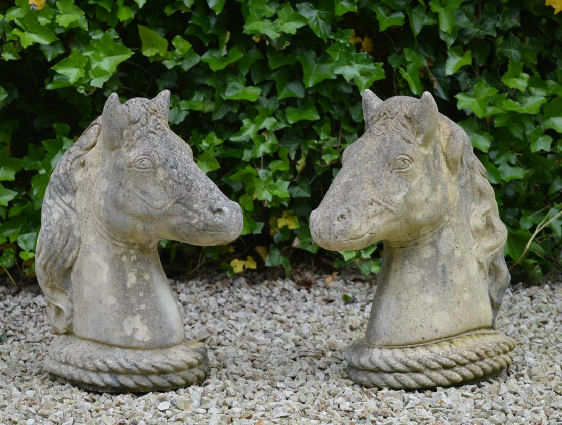 PAIR OF MOULDED STONE SCULPTURES: each representing a horse's head. 50 cm. high; 38 cm. wide Approximate Time: 14:04 Lot No: 606 Category: Garden & Decorative Objects