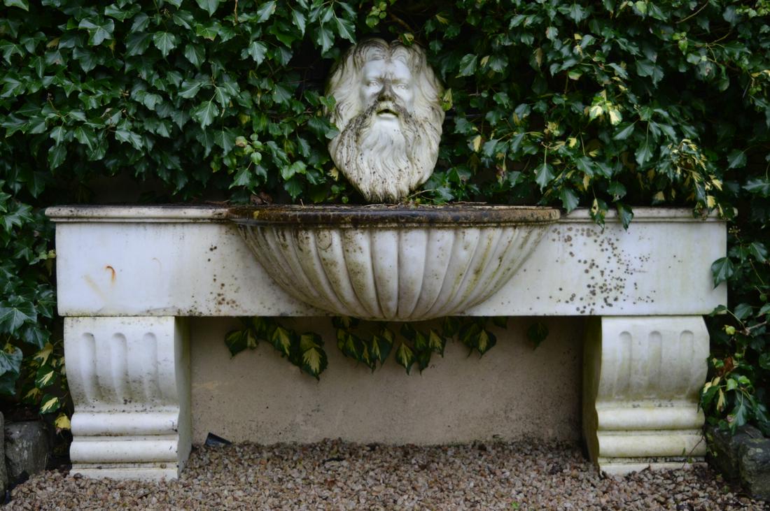 19TH-CENTURY WALL-MOUNTED MARBLE FOUNTAIN: with mask carved spout. 70 cm. high; 180 cm. wide Approximate Time: 14:45 Lot No: 652 Category: Garden & Decorative Objects