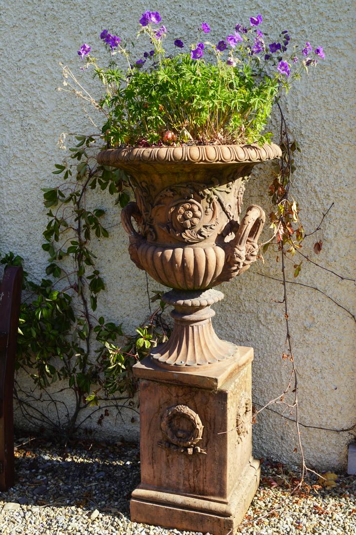 PAIR OF NEO-CLASSICAL TERRACOTTA URNS: with rich moulded decoration, each raised on a square plinth. 127 cm. high; 65 cm. in diameter; Approximate Time: 16:52 Lot No: 793 Category: Garden & Decorative Objects