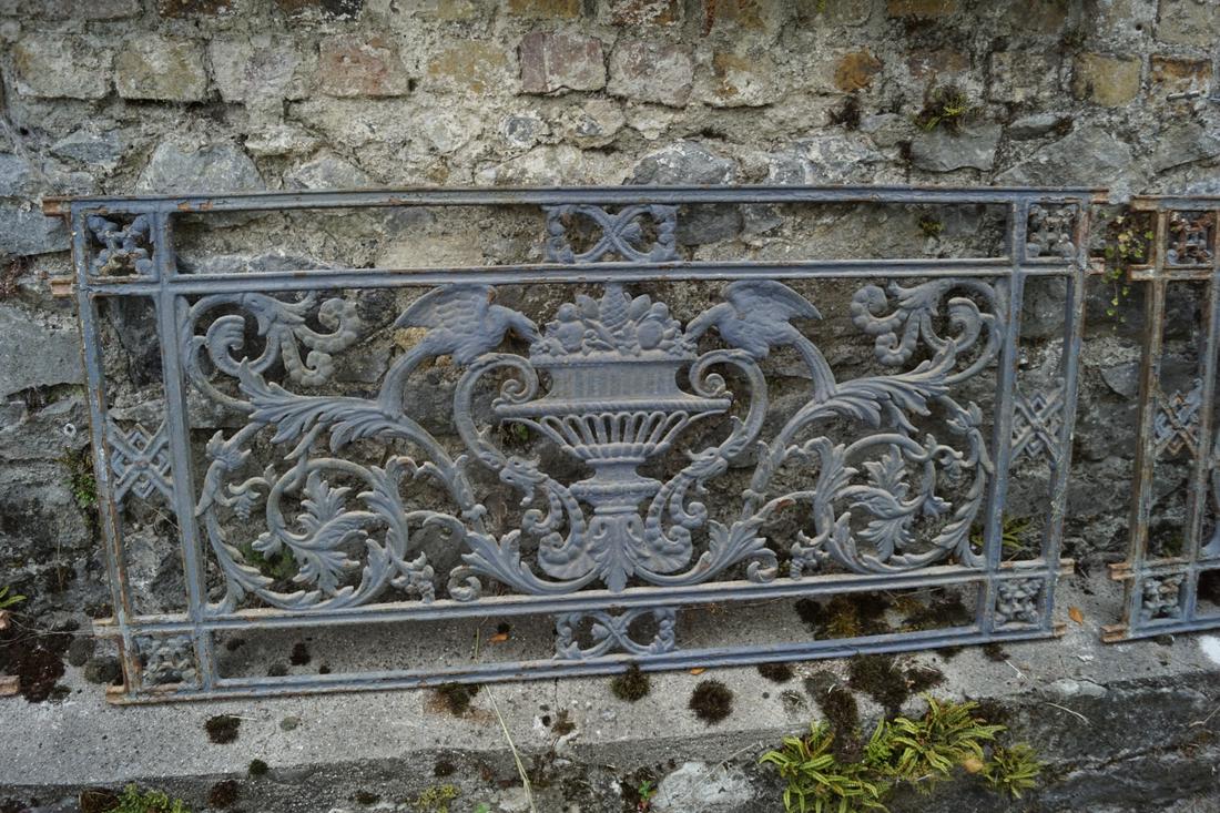 THREE LARGE CAST IRON GARDEN GRILLS: each with profuse leaf scroll centred by a vase. Approximate Time: 17:05 Lot No: 807 Category: Garden & Decorative Objects