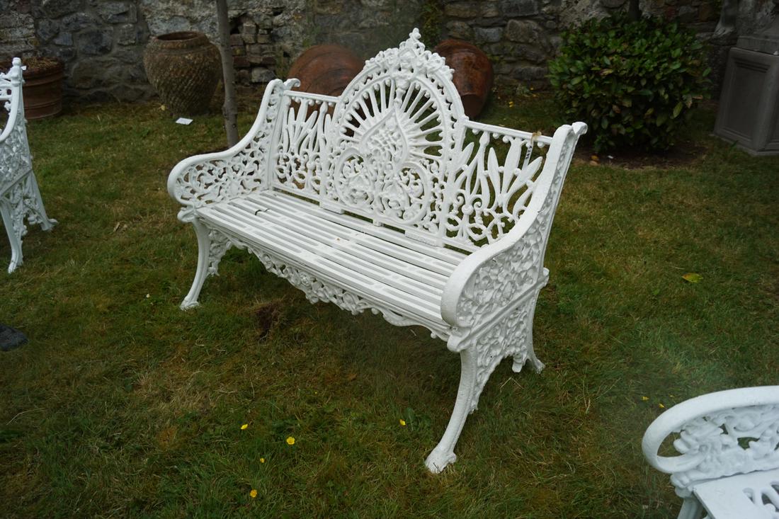 PIERCE OF WEXFORD CAST IRON BENCH: with raised arched panelled back and slatted seat, between scroll ends. 96 cm. high; 120 cm. wide Approximate Time: 17:26 Lot No: 830 Category: Garden & Decorative Objects