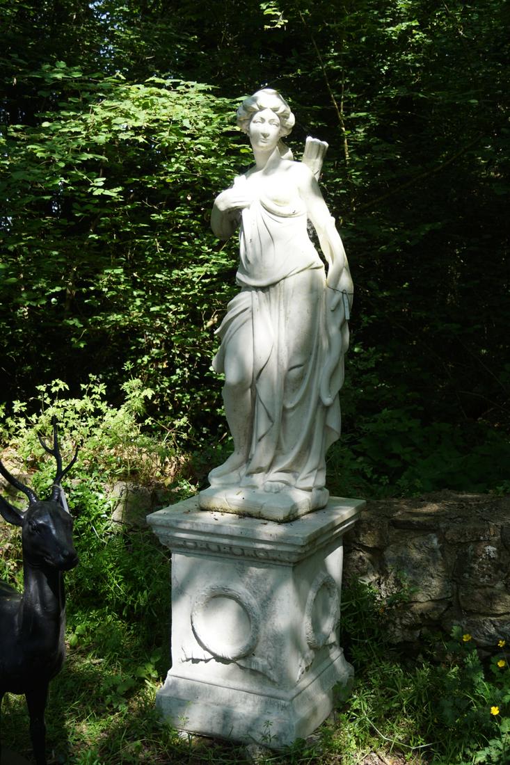 CLASSICAL MOULDED STONE SCULPTURE: Diana the Huntress, raised on a moulded square plinth, centred by a laureate wreath. 214 cm. high Approximate Time: 17:51 Lot No: 863 Category: Garden & Decorative Objects