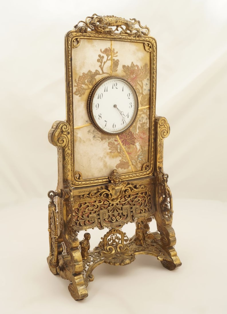 19TH-CENTURY ORMOLU MANTEL CLOCK: the white enamelled dial, mounted on a painted and enamelled floral decorated marble plaque within a bell petal frame, raised on brass pillar scroll ends. 45 cm. high; Approximate Time: 14:30 Lot No: