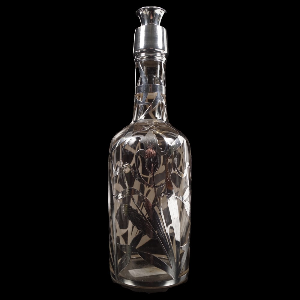 SILVER OVERLAY GLASS DECANTER: with engraved leaf decoration. 30 cm. high; 9 cm. wide; Approximate Time: 11:58 Lot Number: 1199