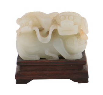 Qing period pale celadon jade carving: Qing period pale celadon jade carving, of Buddhistic lion playing with a brocade ball and with a pup on his back, the jade stone with inclusions, Provenance: Private Jade Collection, County Offaly 6 c