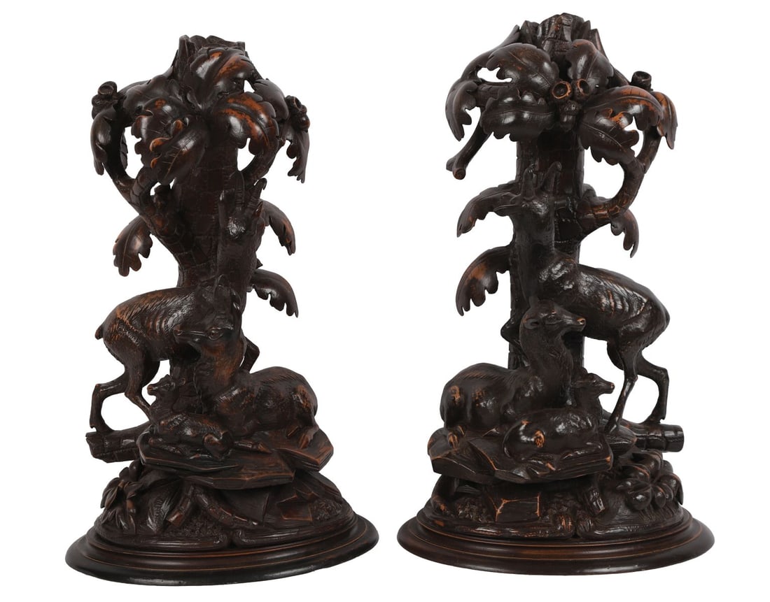 PR BLACK FOREST CARVED WOOD FIGURAL GROUPS: LATE 19TH-CENTURY, Each carved as stags beneath oak foliage, the naturalistic bases incorporating hunting trophies, on circular plinths. SCULPTURE