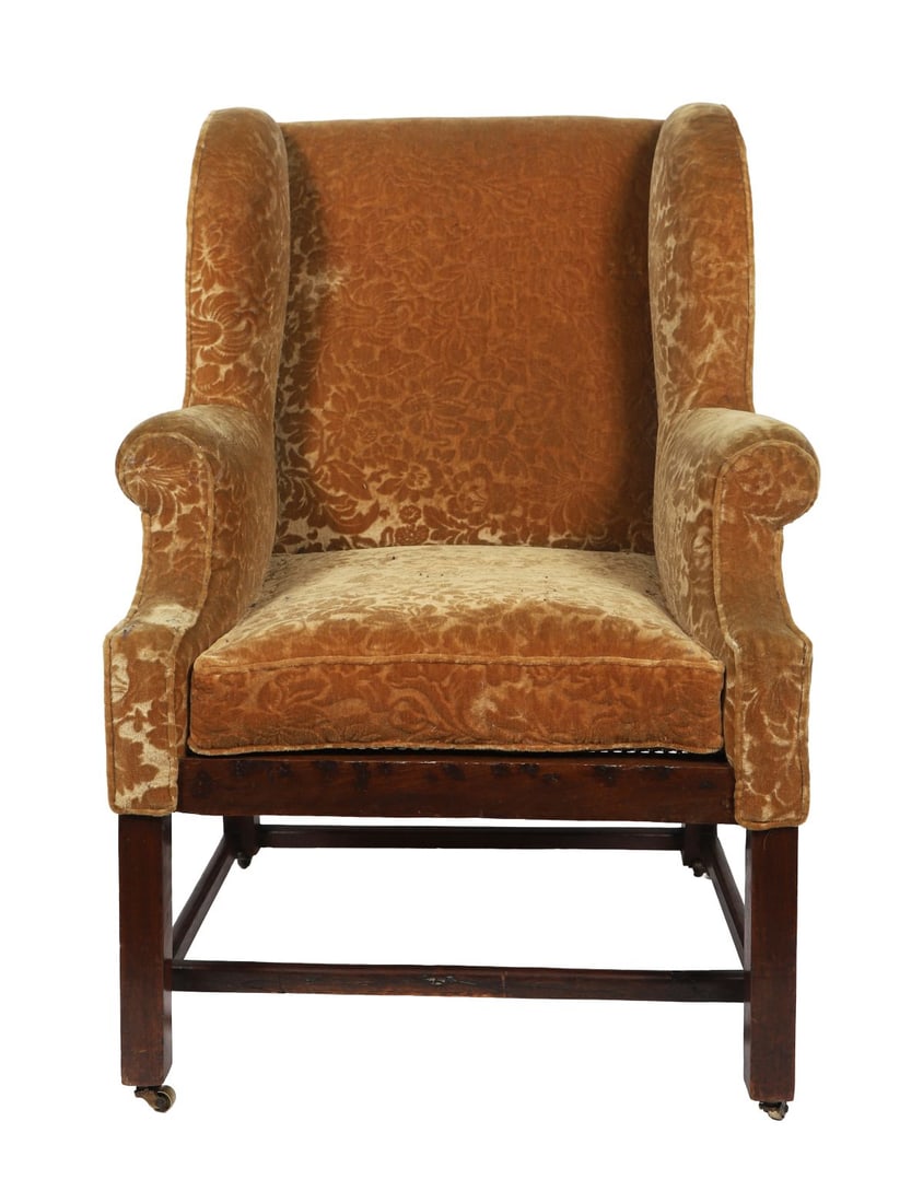 GEORGE III MAHOGANY WINGBACK ARMCHAIR: With shaped winged back and scroll arms above an upholstered seat, raised on square legs joined by stretchers. FURNITURE