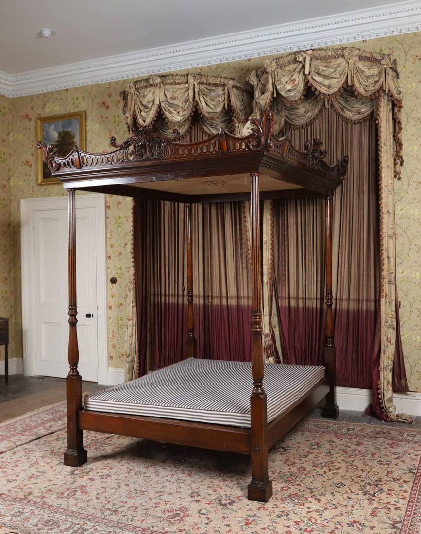 LARGE CHINESE CHIPPENDALE STYLE FOUR-POSTER BED: The rectangular frame with carved uprights and decorative fretwork panels, the posts with stylised carving, in the Chinese Chippendale taste. FURNITURE