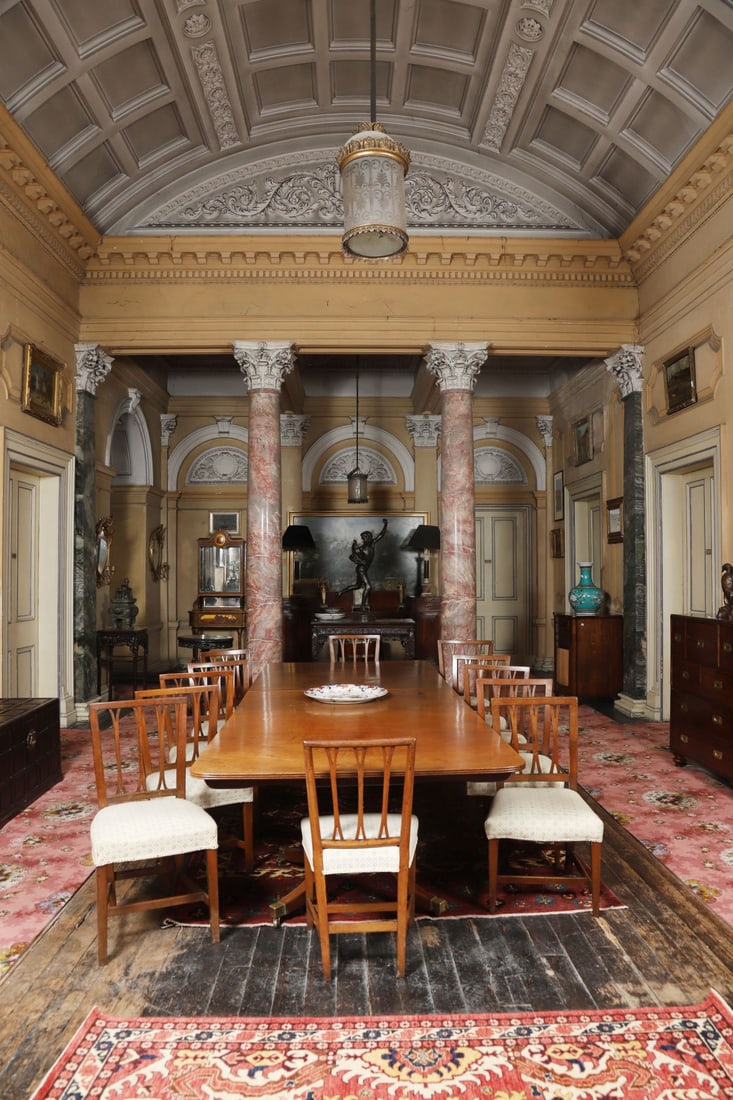 GEORGE III MAHOGANY TWO-PILLAR DINING TABLE: CIRCA 1790, A late 18th-century mahogany twin-pedestal dining table of generous proportion, the rounded rectangular top comprising two D-end sections and a removable centre leaf, raised on turned and 
