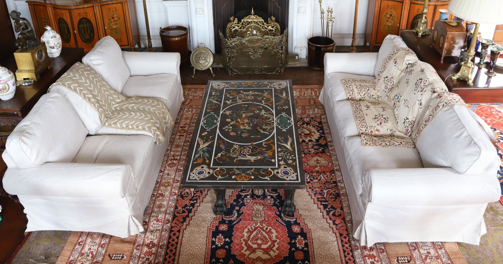 ITALIAN GRAND TOUR MARBLE TOPPED COFFEE TABLE: 20TH-CENTURY, A fine Italian Grand Tour coffee table, the rectangular black marble top profusely inlaid with hardstones in floral and geometric motifs, including lapis lazuli, malachite, and agate, wi