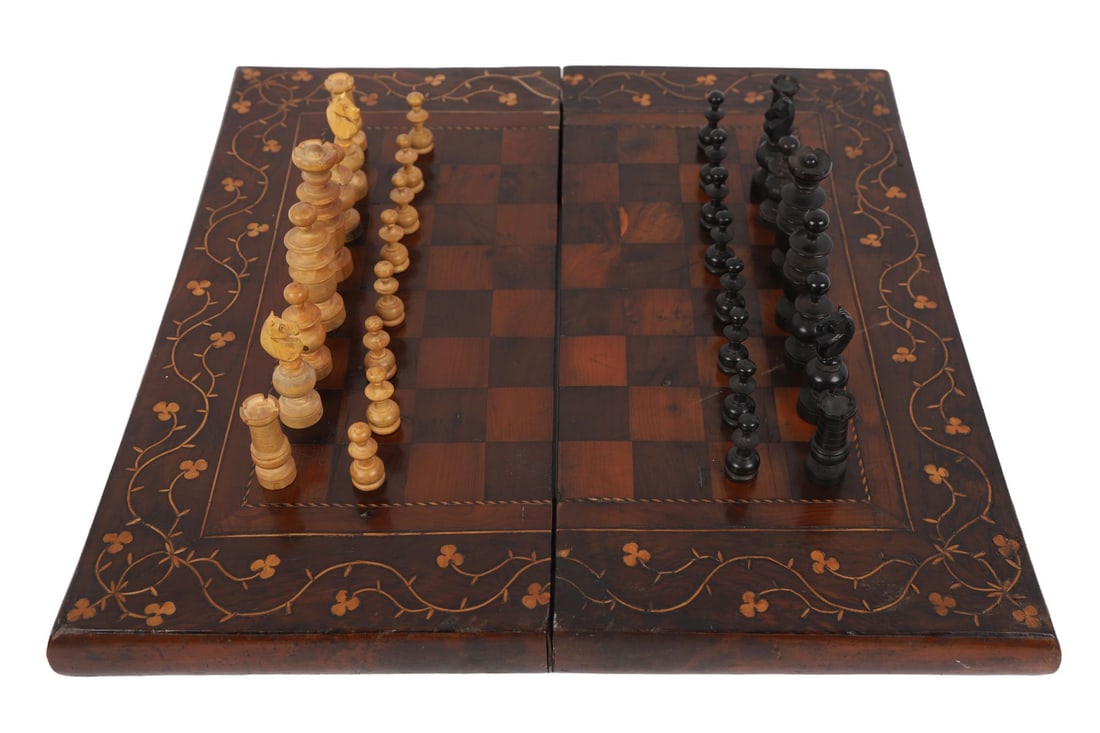 19TH-CENTURY KILLARNEY ARBUTUS&YEWWOOD CHESSBOARD: WITH PIECES. A Victorian Killarney ware chess board, the square playing surface inlaid with alternating yew wood and darker timber squares within a broad border of arbutus wood, decorated with typical