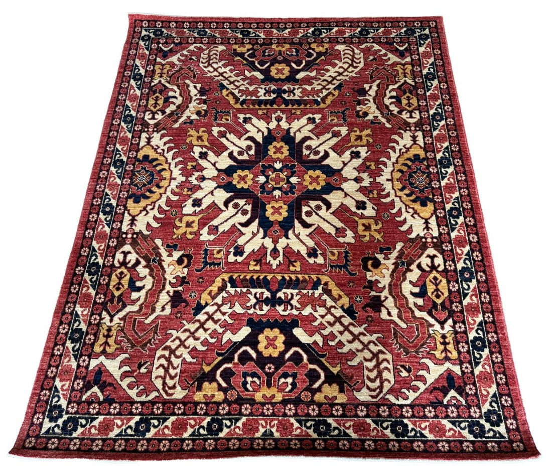 20TH - CENTURY CAUCASIAN CHELABERD KAZAK CARPET: WITH EAGLE MOTIF, Boldly drawn on a rich madder red ground, the field centred by the characteristic Chelaberd “eagle” device, flanked by stylised zoomorphic and geometric elements in ivory, in