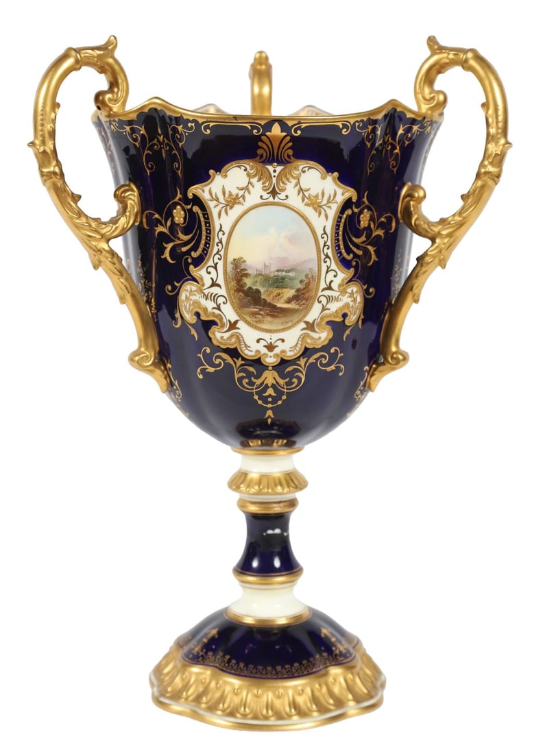 19TH-CENTURY COPELAND PORCELAIN VASE: Of campana form with twin gilt handles, the cobalt ground richly gilt and set with painted landscape reserves, raised on a circular foot. PORCELAIN