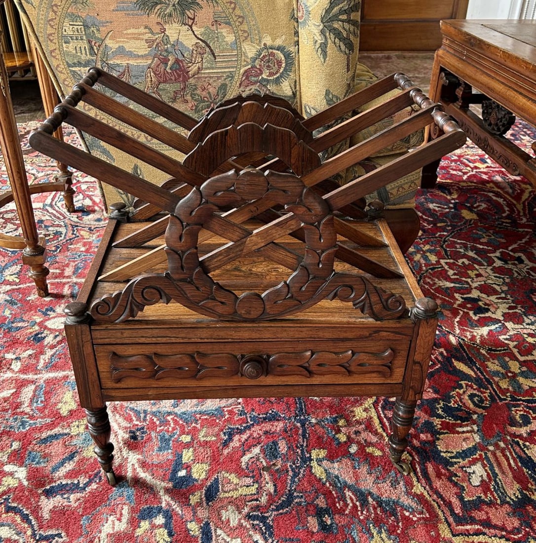 REGENCY ROSEWOOD CANTERBURY: The slatted divisions within a rectangular frame with carrying handle, raised on turned supports and castors. FURNITURE