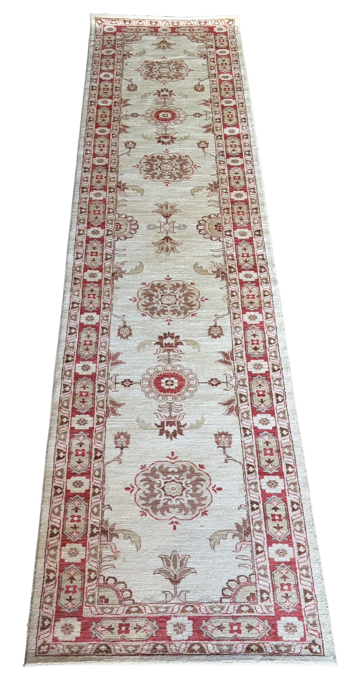 20TH - CENTURY NORTHWEST PERSIAN ZIEGLER RUNNER: The soft ivory ground decorated with a sequence of stylised medallions and floral devices, linked by delicate vinery in muted tones of red, taupe, and blue enclosed within a madder red border with rep