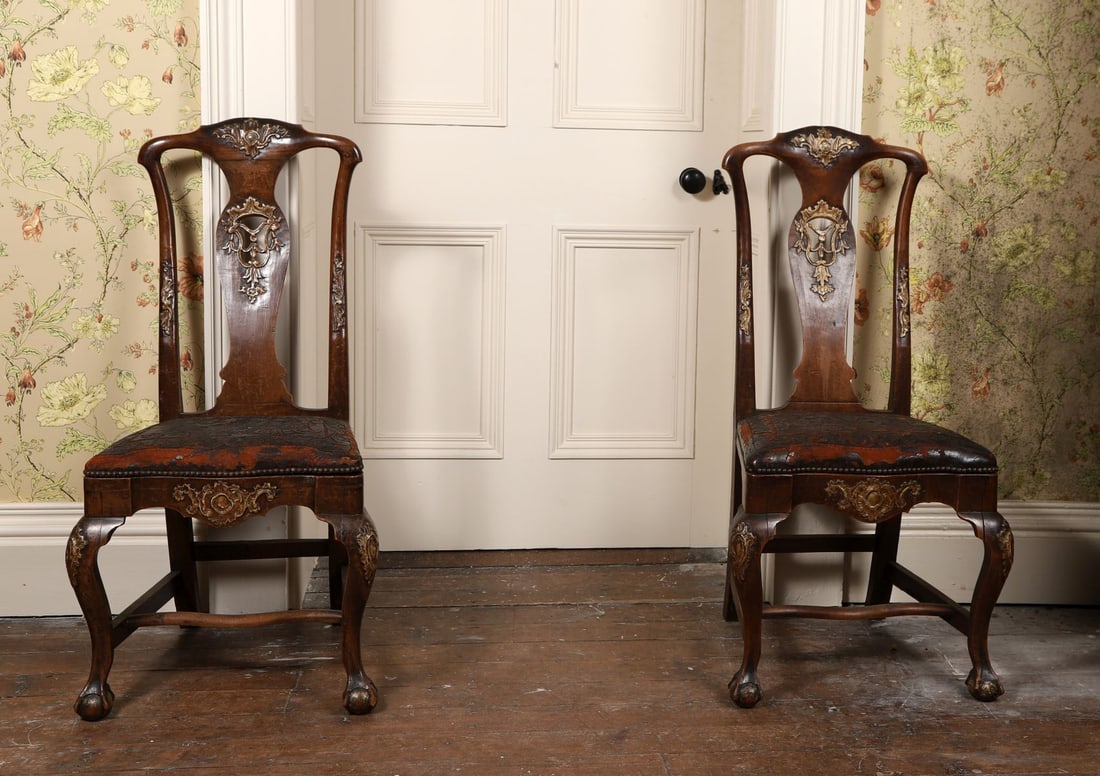 SET OF TWELVE 18TH - CENTURY WALNUT DINING CHAIRS: PARCEL-GILT, Each with shaped back centred by carved splat and gilt ornament, the seats upholstered, raised on cabriole legs. FURNITURE