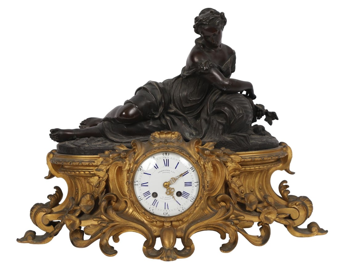FRENCH GILT-BRONZE & PATINATED METAL MANTEL CLOCK: BY CHARPENTIER, PARIS, late 19th century, The case modelled with a seated female figure beside a rococo scrollwork clock housing, the enamel dial with Roman numerals, the movement striking on a bell. 
