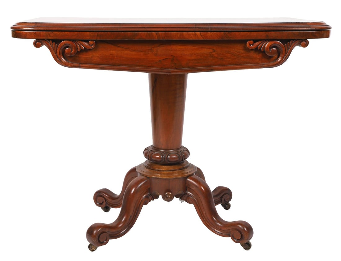 19TH-CENTURY WALNUT FOLD-OVER CARD TABLE: The rectangular top opening to a baize-lined playing surface above a shaped frieze, raised on a central column terminating in a quadripartite base with scroll legs and castors. FURNITURE