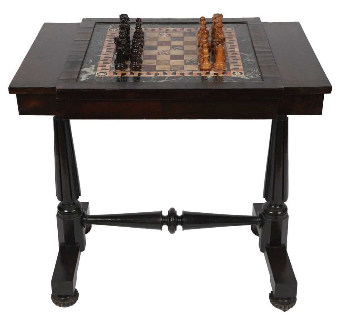 WILLIAM IV EBONY AND SPECIMEN MARBLE GAMES TABLE: WITH CHESS PIECES. A William IV games table, the top inset with specimen marble chessboard, raised on turned supports and stretcher base, complete with a set of chess pieces. SCULPTURE