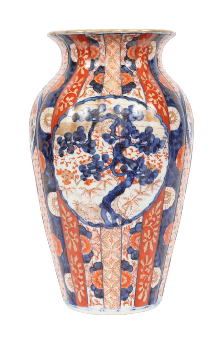 A 19TH CENTURY JAPANESE IMARI LOBBED VASE: A 19th-century Japanese Imari vase of lobed baluster form, decorated with vertical panels of floral ornament and geometric diaper patterns in iron-red and cobalt blue. JAPANESE