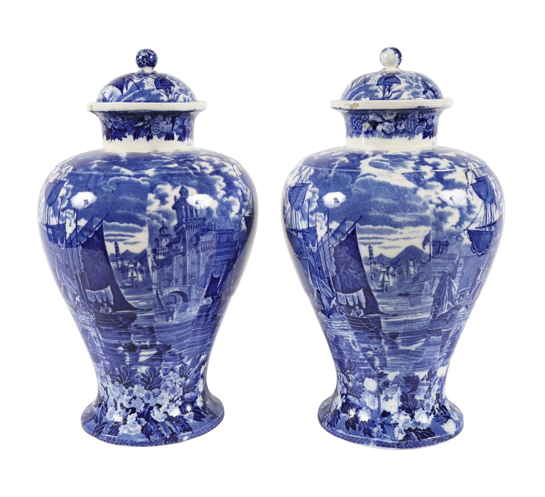A PAIR OF WEDGWOOD BLUE AND WHITE LIDDED JARS: A pair of Wedgwood blue and white lidded jars, of baluster form, decorated with classical landscape scenes and foliate borders, each with domed cover and knop finial. CERAMICS