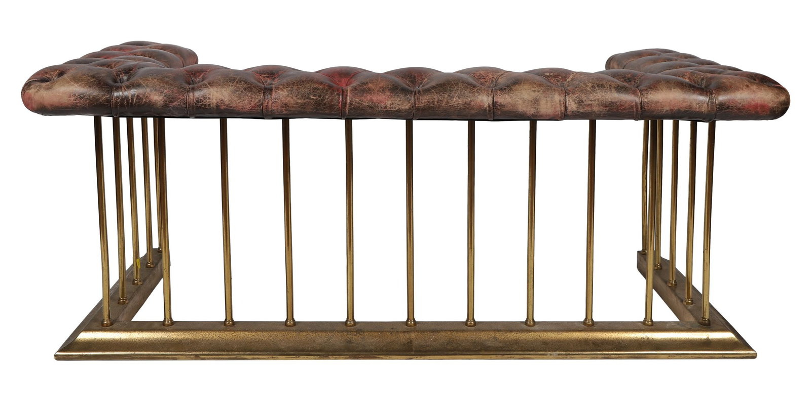 LARGE EDWARDIAN CLUB FENDER: BRASS AND HIDE-UPHOLSTERED, Of straight-fronted form with deep buttoned hide seat above a pierced brass gallery, raised on turned rail supports and a moulded base. FIRE FURNITURE