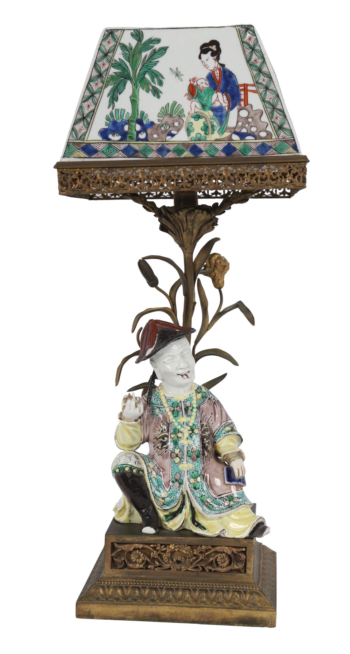 SAMSON FAMILLE VERTE FIGURE-STEMMED TABLE LAMP: A 19th-century Samson porcelain table lamp, the base modelled as a seated Oriental figure in famille verte palette, surmounted by a shaped porcelain panel shade decorated with figures in an interior s