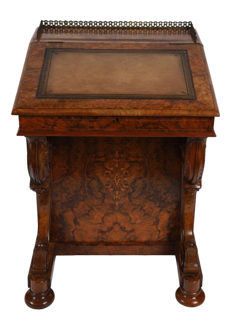 VICTORIAN WALNUT AND MARQUETRY DAVENPORT: A walnut davenport, the slope-front with gilt-tooled leather inset and three-quarter brass gallery, the sides fitted with drawers and cupboard, raised on carved scroll supports. FURNITURE