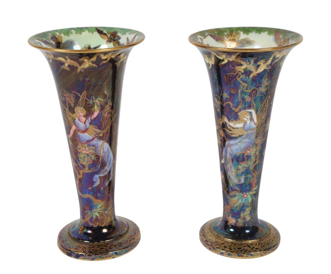 PR 20TH-CENTURY WEDGWOOD FAIRYLAND LUSTRE VASES: Pair of flared trumpet-form vases with dark iridescent lustre grounds, decorated with winged fairy figures, trees, and foliage in gilt and polychrome enamels, in the Fairyland Lustre manner. CERAMICS