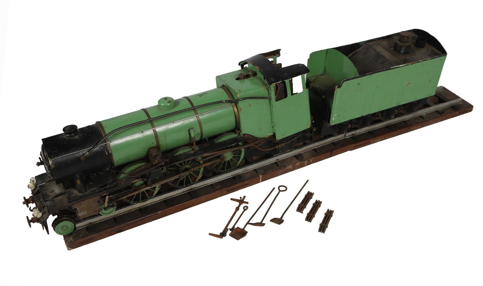 19TH-CENTURY METAL MODEL OF A STEAM ENGINE: A large-scale model with locomotive and tender, finished in green and black paintwork, detailed with wheels, chimney, and mechanical fittings. MODEL TOYS