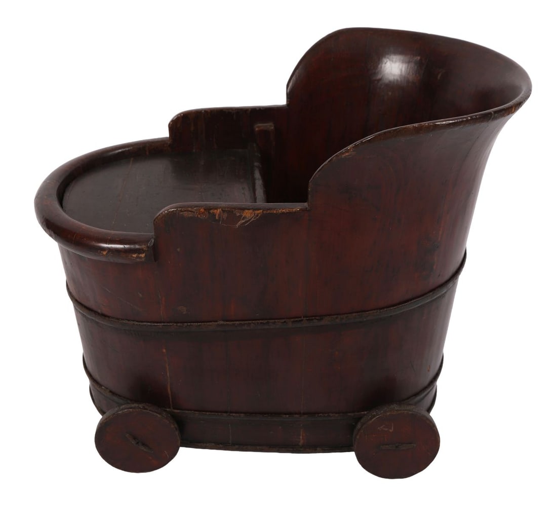 19TH-CENTURY CHILD’S STROLLER: Unusual wooden child’s stroller of tub form, with curved sides, iron banding and small disc wheels, retaining original surface and patina. FURNITURE
