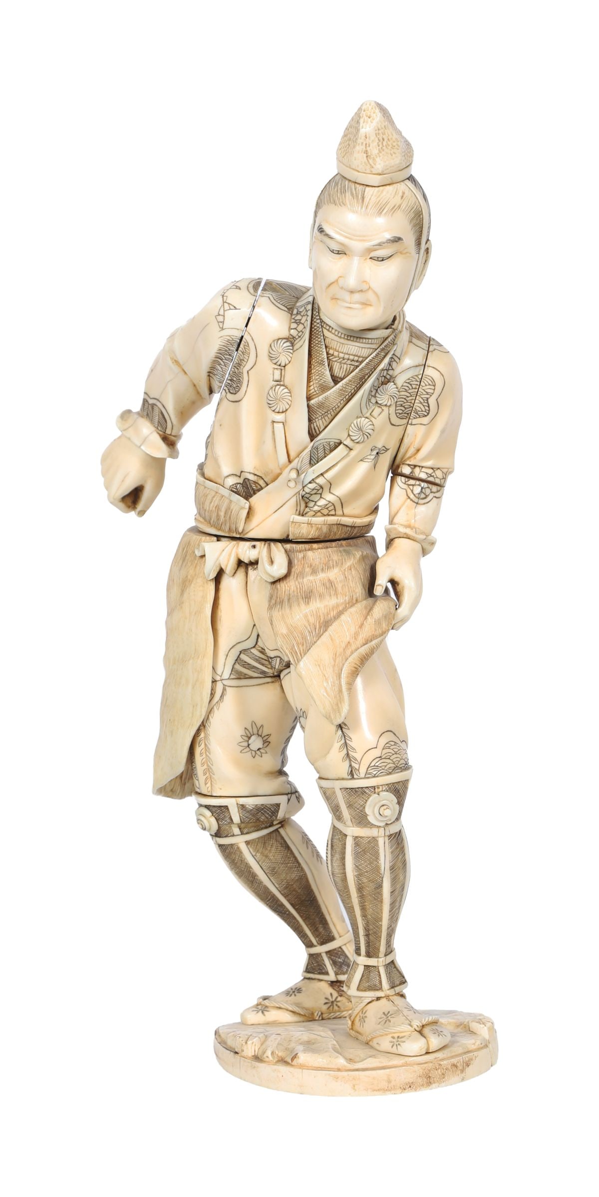 JAPANESE MEIJI PERIOD IVORY FIGURE: Carved figure of a standing man.A finely carved figure in traditional dress with engraved decoration to the robe, standing on a circular base. JAPANESE