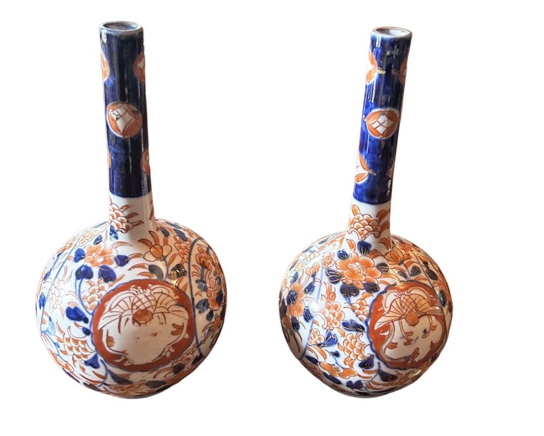 PAIR 19TH CENTURY JAPANESE IMARI VASES: A pair of 19th-century Japanese Imari bottle-shaped vases, each with globular body and narrow neck, decorated with panels of flowers and stylised ornament in iron-red and cobalt blue. JAPANESE