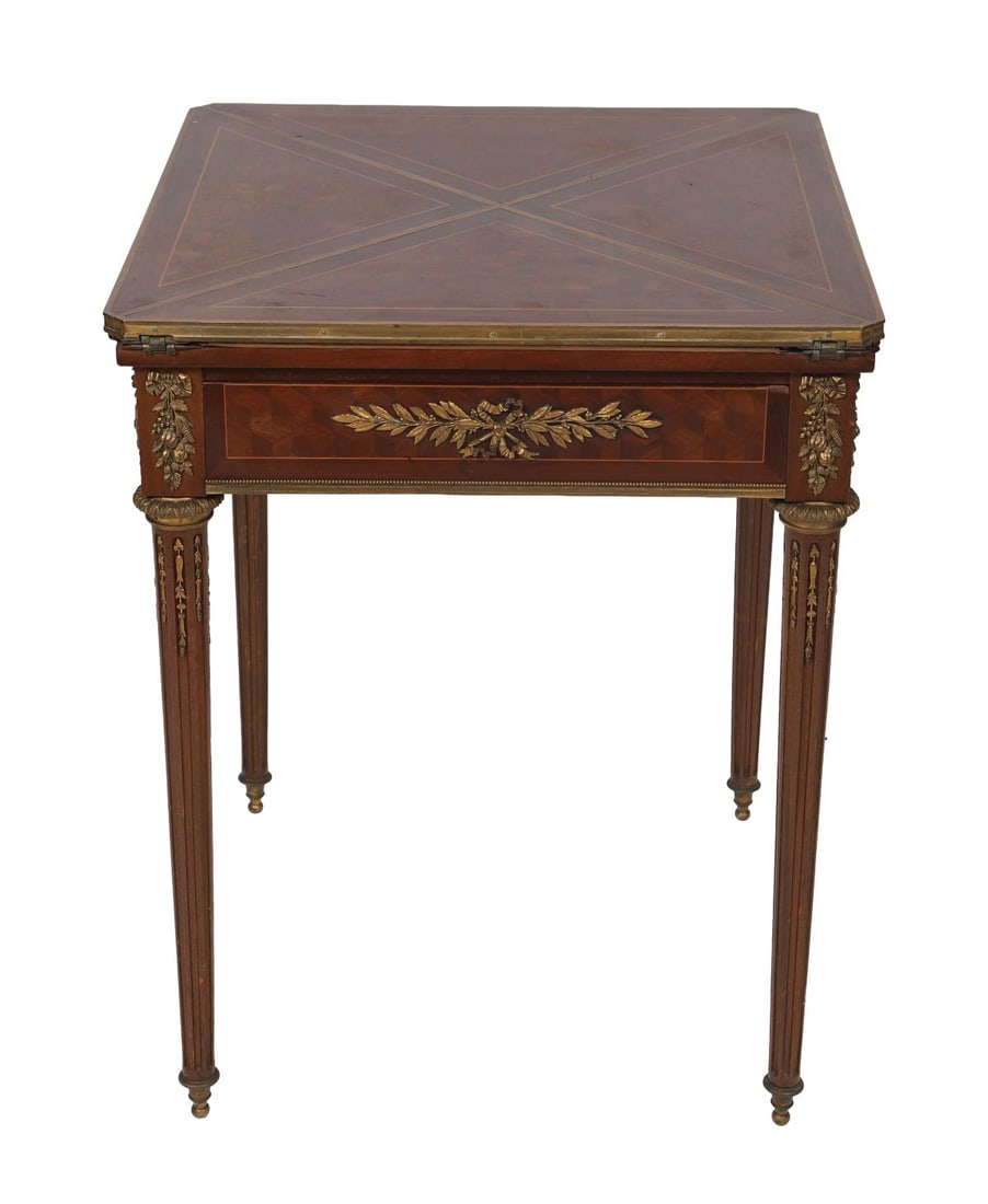 19TH-CENTURY FRENCH KINGWOOD ENVELOPE CARD TABLE: ORMOLU-MOUNTED. The hinged envelope top opening to a crossbanded and inlaid playing surface, above a frieze with applied ormolu mounts, raised on slender fluted legs. FURNITURE