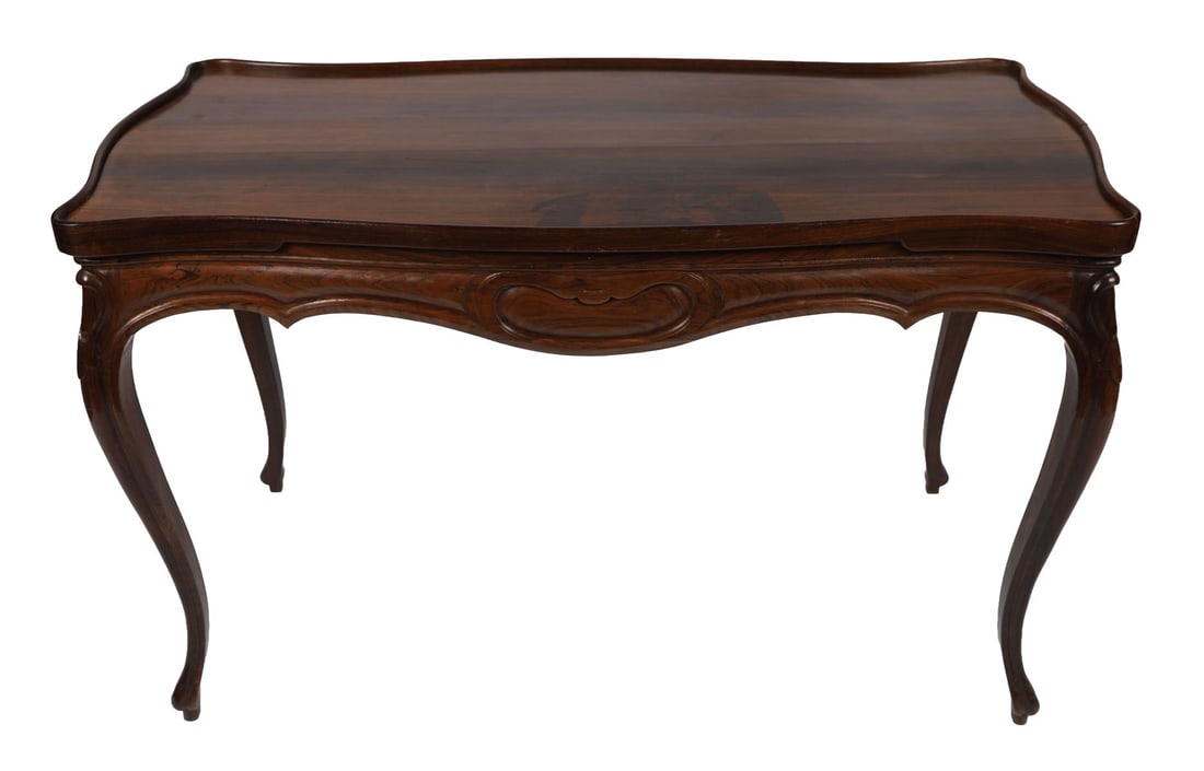 ROSEWOOD GAMES TABLE WITH DOMINO INTERIOR: A 19th-century rosewood games table of shaped rectangular form, raised on cabriole supports, the lift-off top revealing a fitted interior with compartments for dominoes or gaming pieces, the frieze