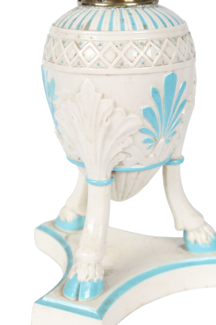 FIRST PERIOD BELLEEK PORCELAIN TABLE LAMP: WITH ETCHED SHADE, A first period Belleek porcelain table lamp, the body moulded with classical ornament and picked out in pale blue and gilt, raised on tripod supports, fitted with a cranberry-tinted