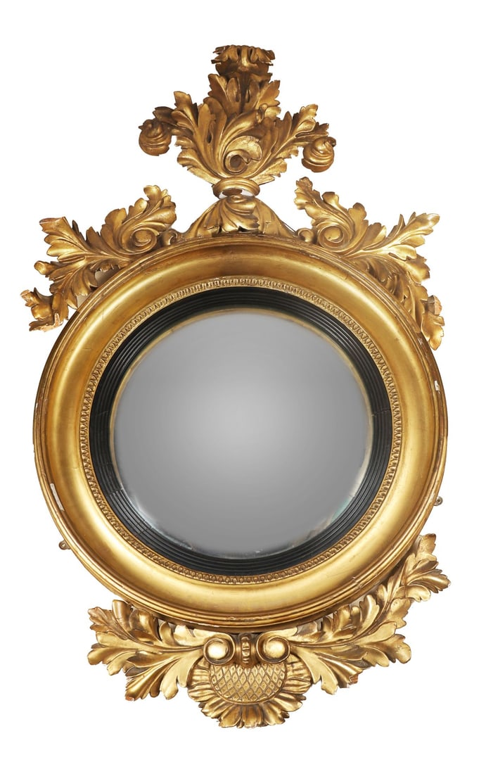 REGENCY GILTWOOD CONVEX WALL MIRROR: Of circular form with ebonised slip and convex plate, the frame surmounted by an acanthus-carved crest. MIRRORS