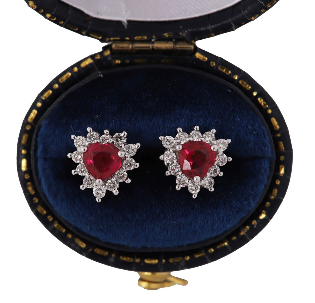 PAIR RUBY AND DIAMOND CLUSTER EARRINGS: Pair of earrings, each set with an oval-cut red stone within a surround of brilliant-cut diamonds, in white metal mounts. JEWELLERY