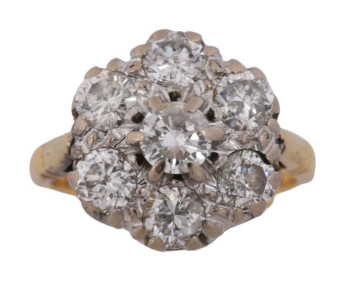 EARLY 20TH - CENTURY DIAMOND CLUSTER RING: A diamond cluster ring set with a central old-cut diamond within a surround of further old-cut diamonds forming a floral cluster, mounted in white metal on a yellow metal shank. Housed in a fitted cas