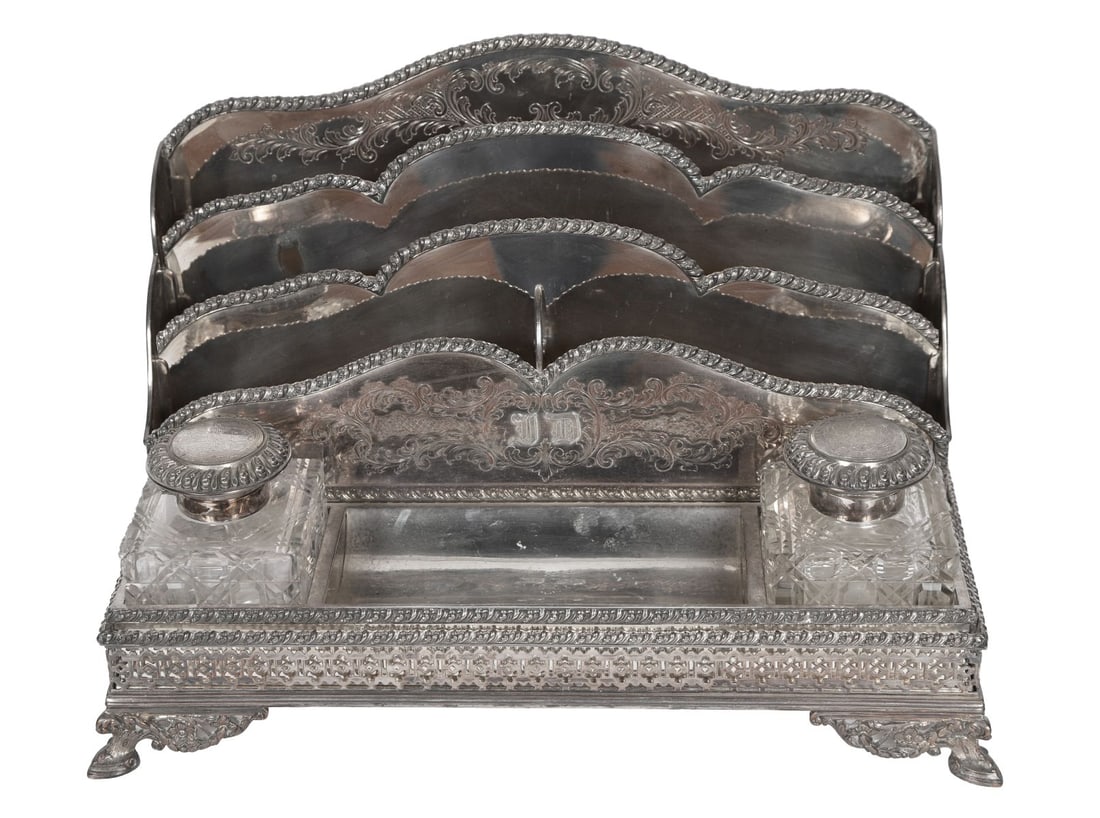 LATE 19TH-CENTURY SILVER-PLATED DESK STAND: With shaped gallery back and twin inkwells, raised on a rectangular base with beaded borders. SILVER AND SILVER PLATE