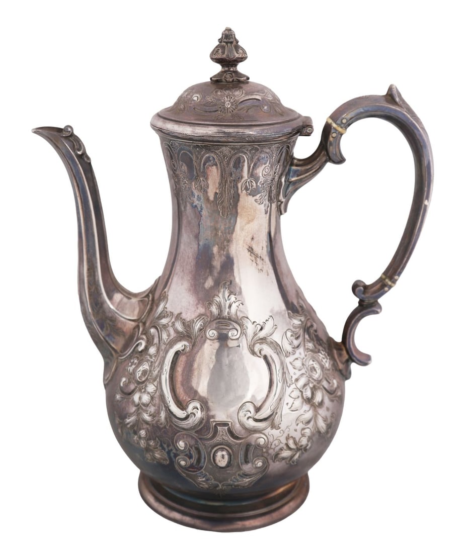 VICTORIAN SHEFFIELD SILVER EWER, 1884: Of baluster form with scroll handle and shaped spout, the body richly decorated in repoussé with scrolling foliate ornament, the domed hinged cover with finial, raised on a circular foot, fully hallm