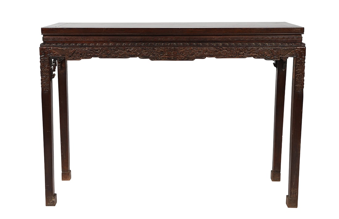 CHINESE QING HARDWOOD DRAGON-CARVED ALTAR TABLE: The rectangular top above a finely carved frieze decorated with scrolling dragons and foliage, centred by a shaped cartouche, raised on square tapering supports with carved corner brackets. 86 cm. hig
