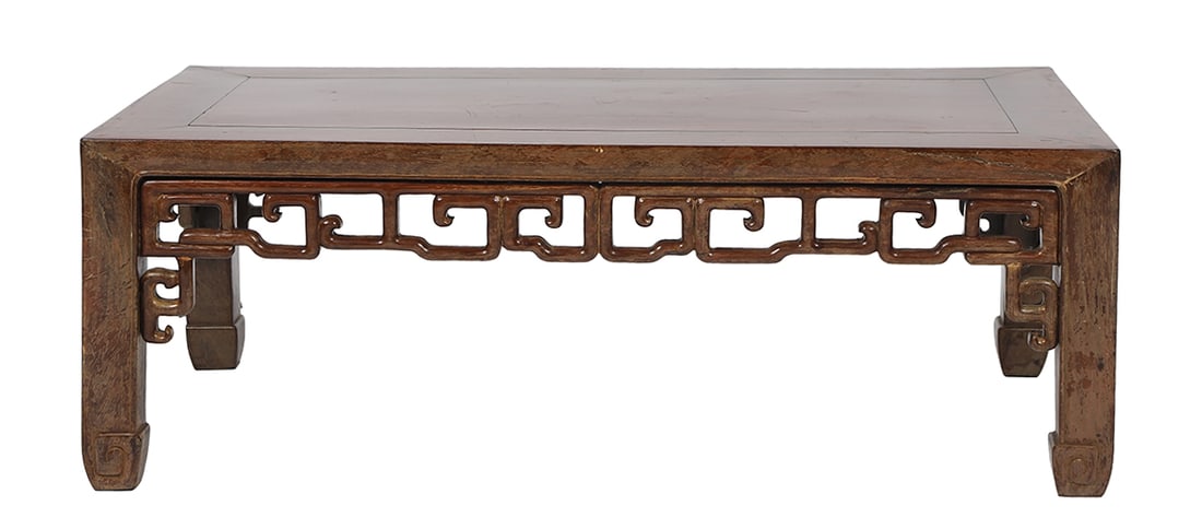 CHINESE QING HARDWOOD LOW TABLE: The rectangular inset panel top above an open fret-carved apron of geometric form, raised on square supports with stylised scroll terminals. 28 cm. high; 76 cm. wide; 40 cm. deep