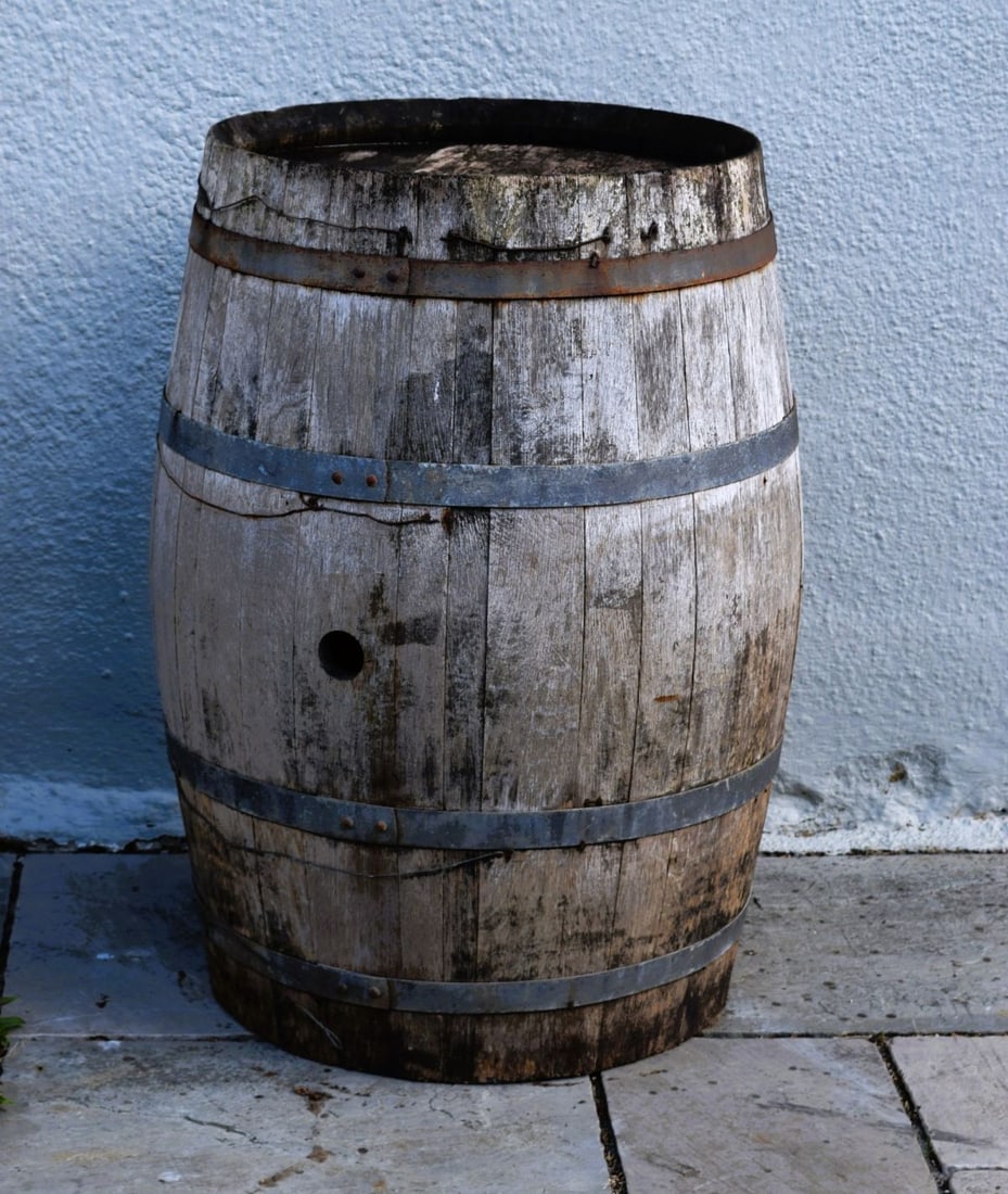 19TH-CENTURY OAK BARREL: 19th-century oak barrel with iron hoop bindings and weathered surface patination.