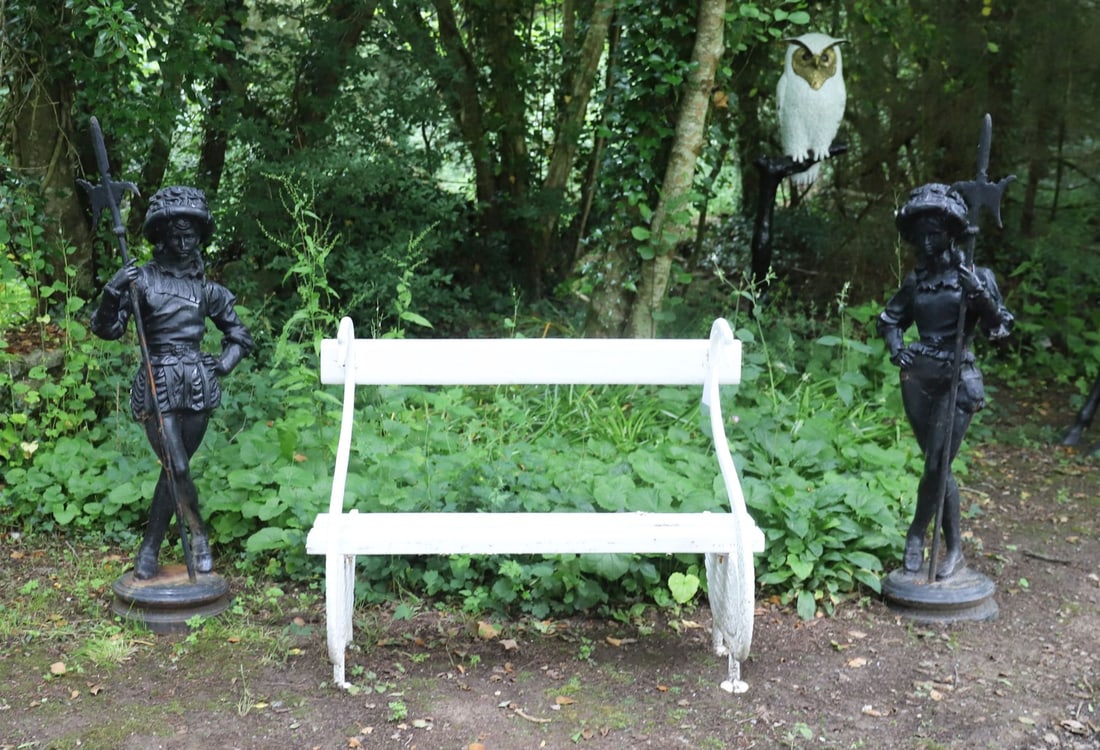 PAIR OF VICTORIAN STYLE CAST IRON FIGURES: OF RENAISSANCE PAGES Pair of Victorian cast iron garden figures modelled as Renaissance pages or attendants, each depicted standing in a relaxed pose with crossed legs, wearing feathered hats and peri